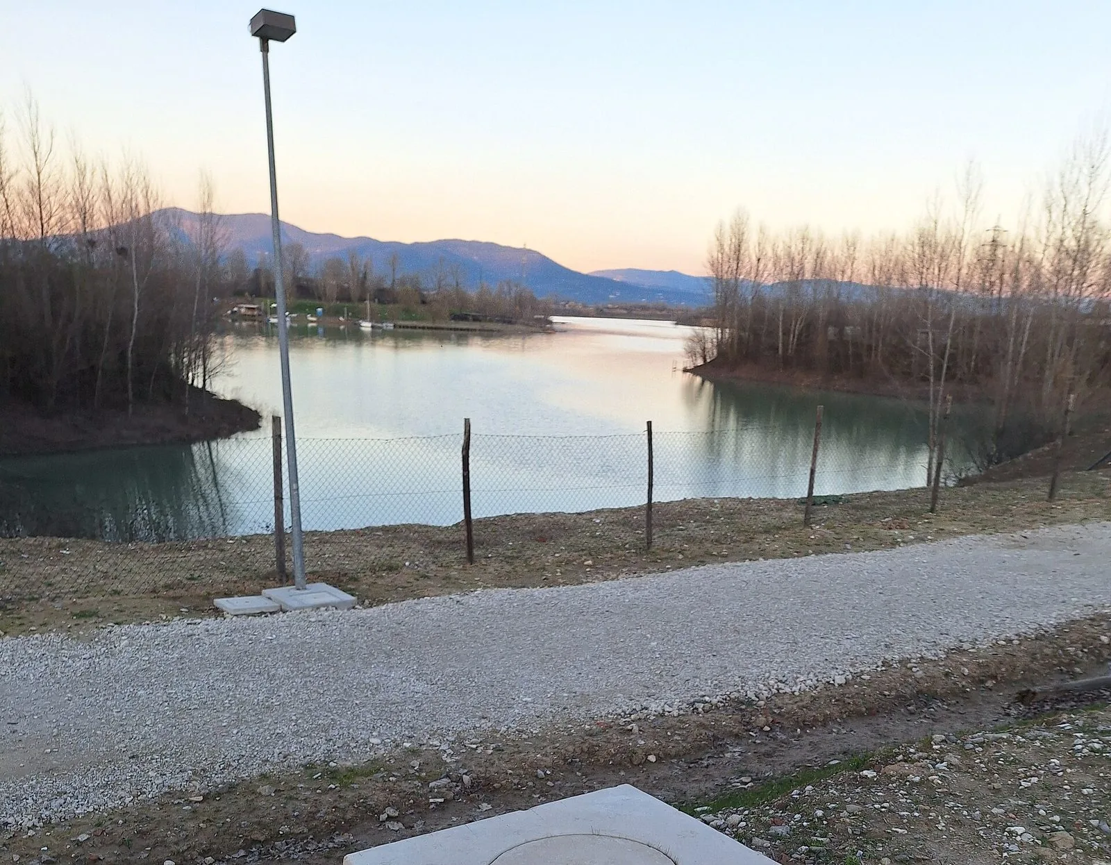 Il lago del parco dei Renai a Signa al tramonto, con le colline sullo sfondo